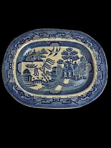 Antique faience serving dish with Chinese pattern. The pattern is called Blue 
Willow. Presumably English, Staffordshire. Indistinctly marked.