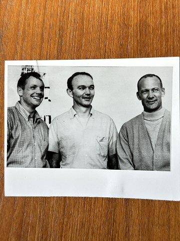 NASA: Small original black and white photograph of the three Apollo 11 
astronauts Neil Armstrong, Mike Collins and Edwin Aldrin, gelatin silver, July 
1969 with the Apollo V rocket in the background