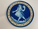 French faience plate / wall plaque with motif of 
blue girl with long braids in relief. The girl 
dances and plays music with castanets and 
tambourine, first half of the 20th century