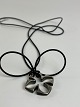 Clover-shaped pendant from Toftegaard Design made of 925 sterling silver in a 
long chain of natural rubber.