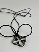 Clover-shaped pendant from Toftegaard Design made 
of 925 sterling silver in a long chain of natural 
rubber.