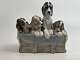 Lladro figure with dogs, probably by Juan Huerta, 
4 puppies with blanket; sitting on a "wooden box", 
20th century